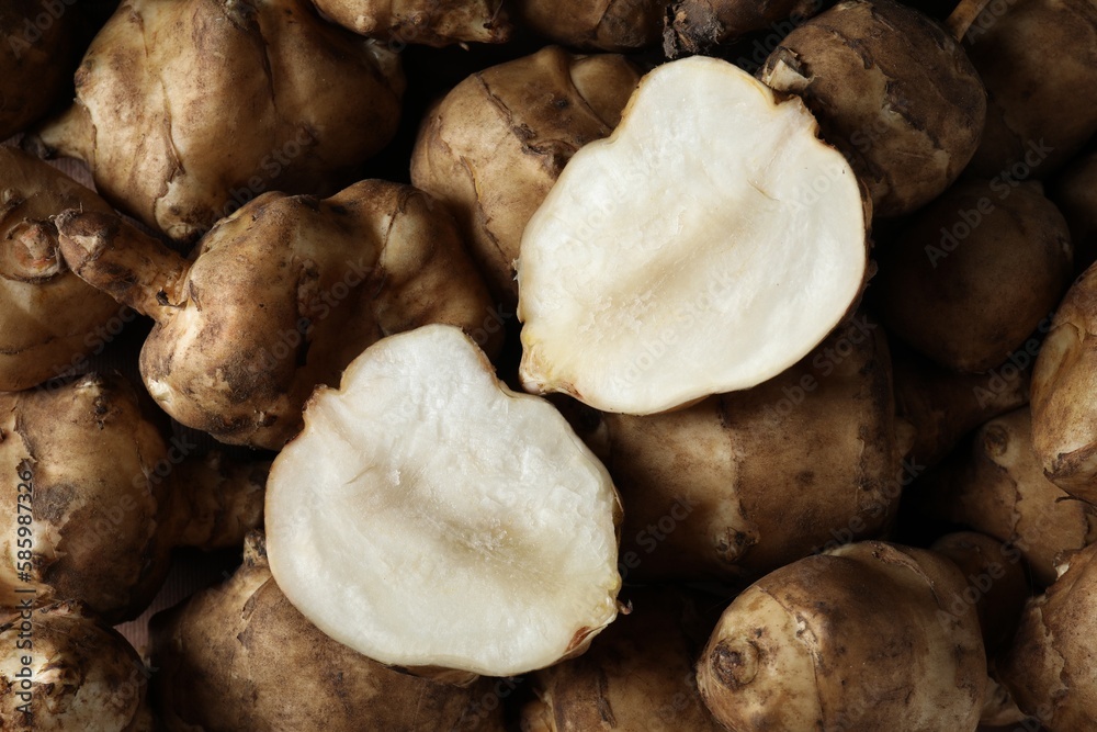 Whole and cut Jerusalem artichokes as background, top view Whole and cut Jerusalem artichokes as background, top view