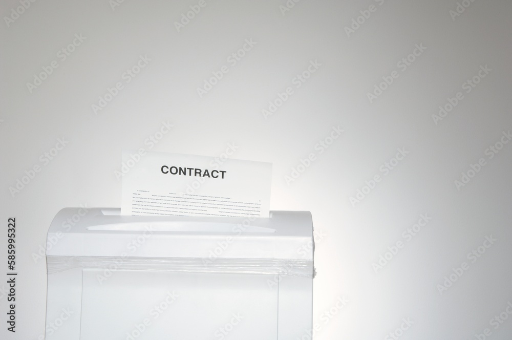 Contract paper in a shredder with copy space Contract paper in a shredder with copy space