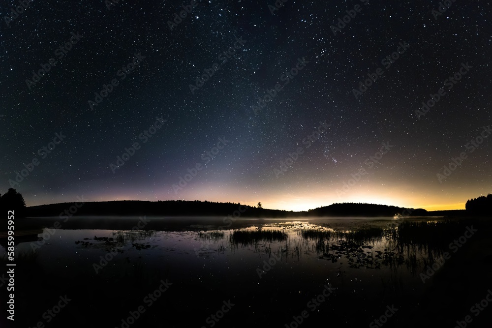 a large body of water under a clear sky with a star filled sky