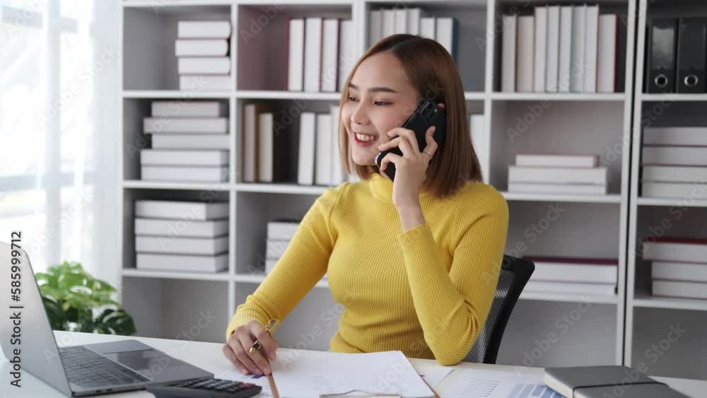 Happy asian businesswoman using a smartphone in a creative office. Happy asian businesswoman using a smartphone in a creative office.
