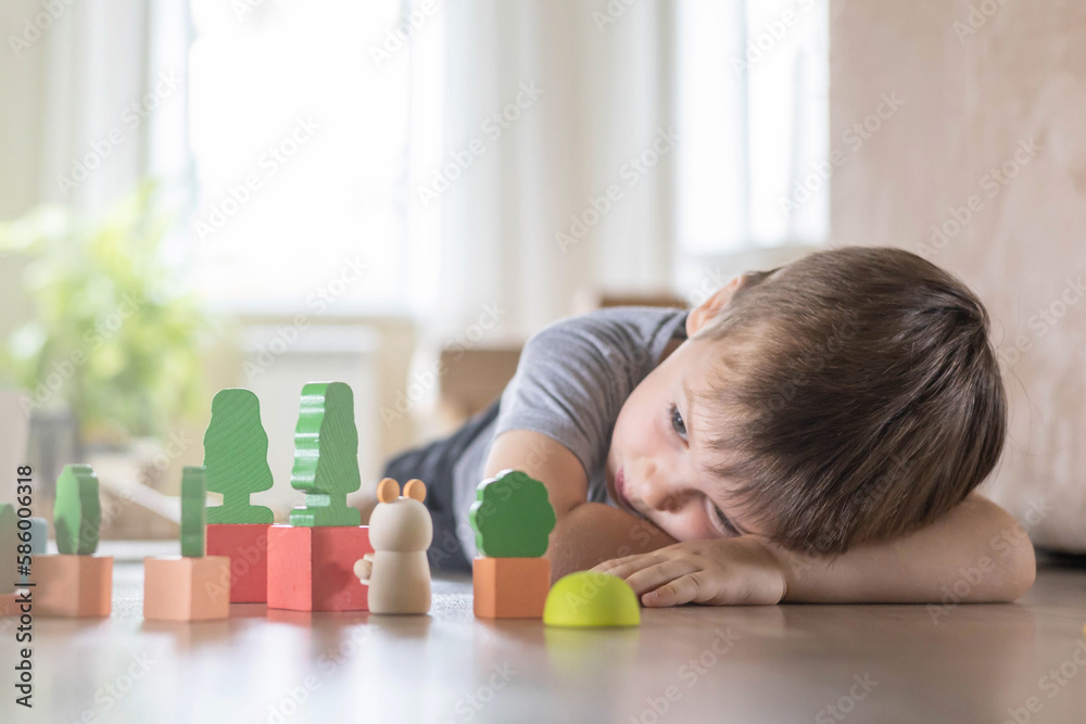 Confident male kid building fortress tower architecture wooden bricks ecology Montessori material Confident male kid building fortress tower architecture wooden bricks ecology Montessori material