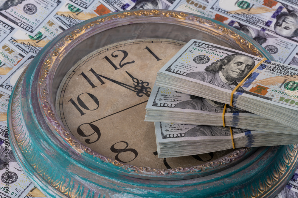 100 American dollar bills and the dial of a large wall clock