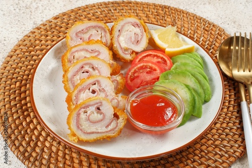 Sliced Chicken cordon bleu and a salad on a plate  photo