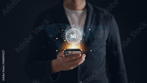 Man using his phone with a 5G sign, representing the latest wireless technology and high-speed connectivity. 