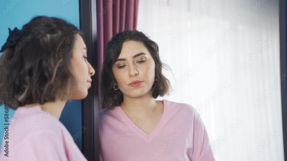 Unhappy and depressed young woman looking in mirror.
Sad and unhappy young woman looking in the mirror at home.
Unhappy and depressed young woman looking in mirror.
Sad and unhappy young woman looking in the mirror at home.
