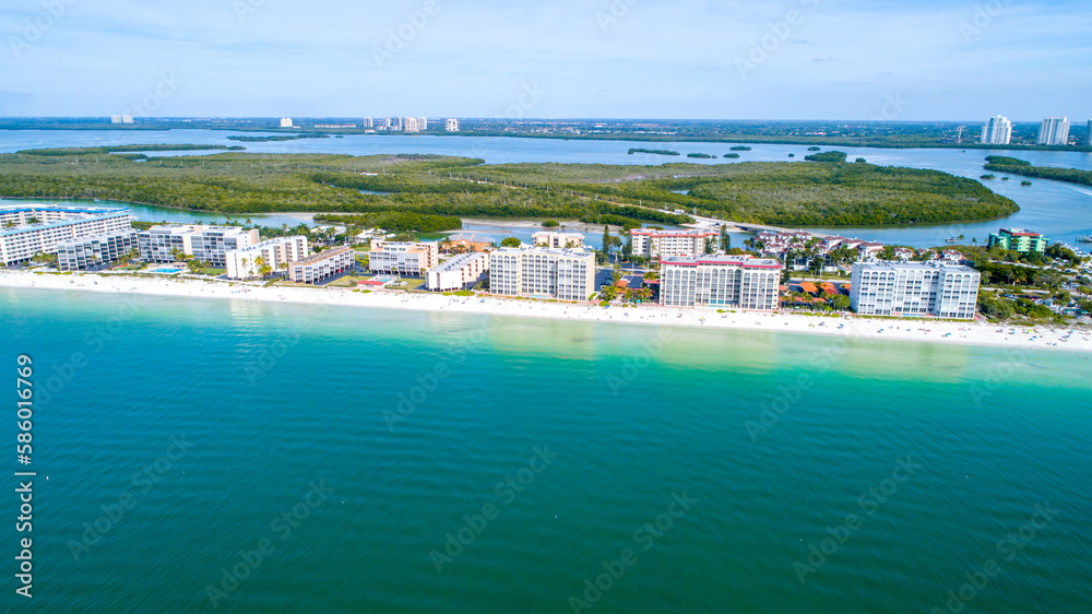 Drones Eye View of Barefoot Beach in Bonita Springs, Florida Featuring Real Estate and White Sand Beach in the Foreground and Blue Bay Waters in the Background Surrounded by Mangroves