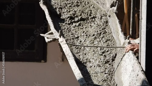 Workers are spreading the concrete that flows and pouring from a cement mixer truck, Concrete for flooring.