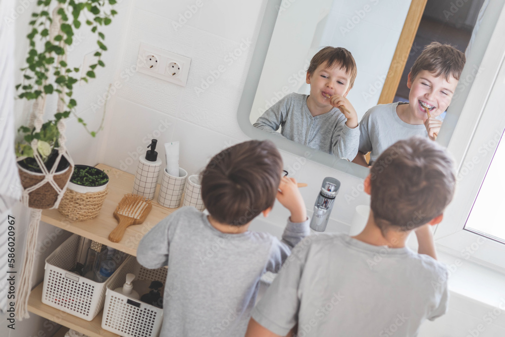 Brother morning fun male kids cleaning teeth toothbrush in front of mirror sink at bathroom Brother morning fun male kids cleaning teeth toothbrush in front of mirror sink at bathroom