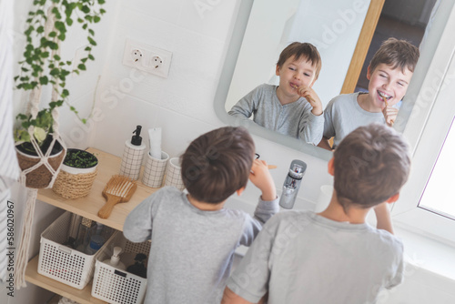Brother morning fun male kids cleaning teeth toothbrush in front of mirror sink at bathroom