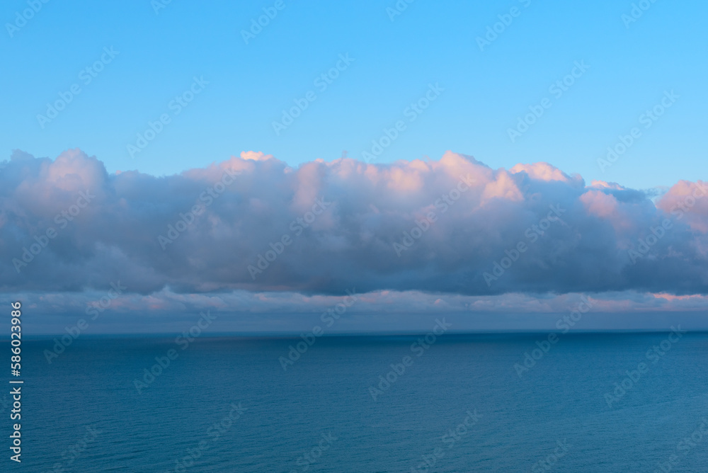 Nature background with blue sea against cloudy sky during beautiful sunrise. Beauty of nature or travel concept