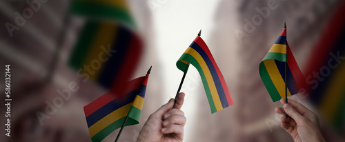 A group of people holding small flags of the Mauritius in their hands photo