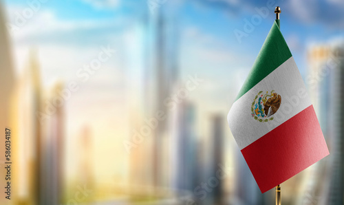 A small Mexico flag on an abstract blurry background photo