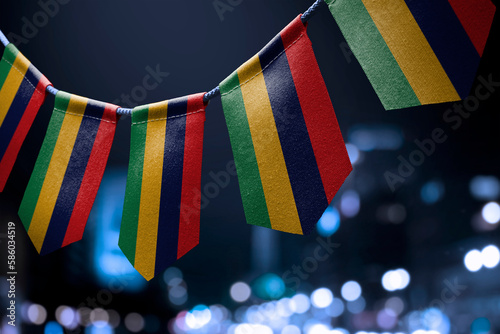 Fototapeta Naklejka Na Ścianę i Meble -  A garland of Mauritius national flags on an abstract blurred background