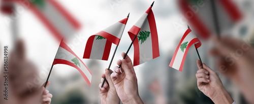 Fototapeta Naklejka Na Ścianę i Meble -  A group of people holding small flags of the Lebanon in their hands