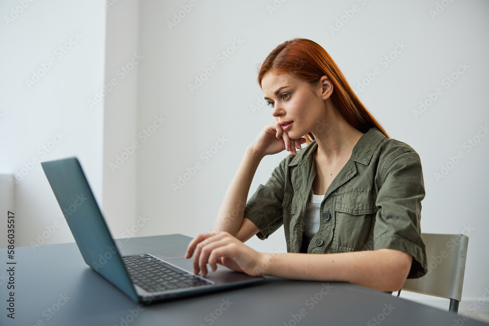 a woman sits at work at the table and looks thoughtfully, solving work issues in the office a woman sits at work at the table and looks thoughtfully, solving work issues in the office