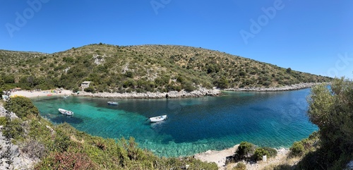 Panoramic view of beach and boats on the crystal clear blue and turquoise waters of Brbinjšćica Bay on Dugi Otok Island off the coast of Zadar in Dalmatia, Croatia