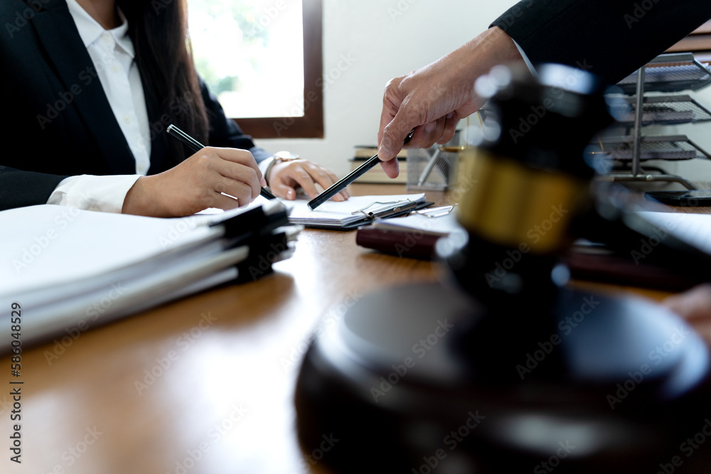 Law firms discussing with pen pointing at documents Law firms discussing with pen pointing at documents
