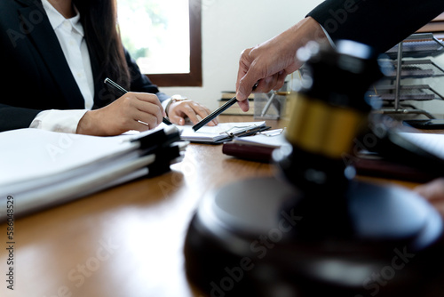 Law firms discussing with pen pointing at documents