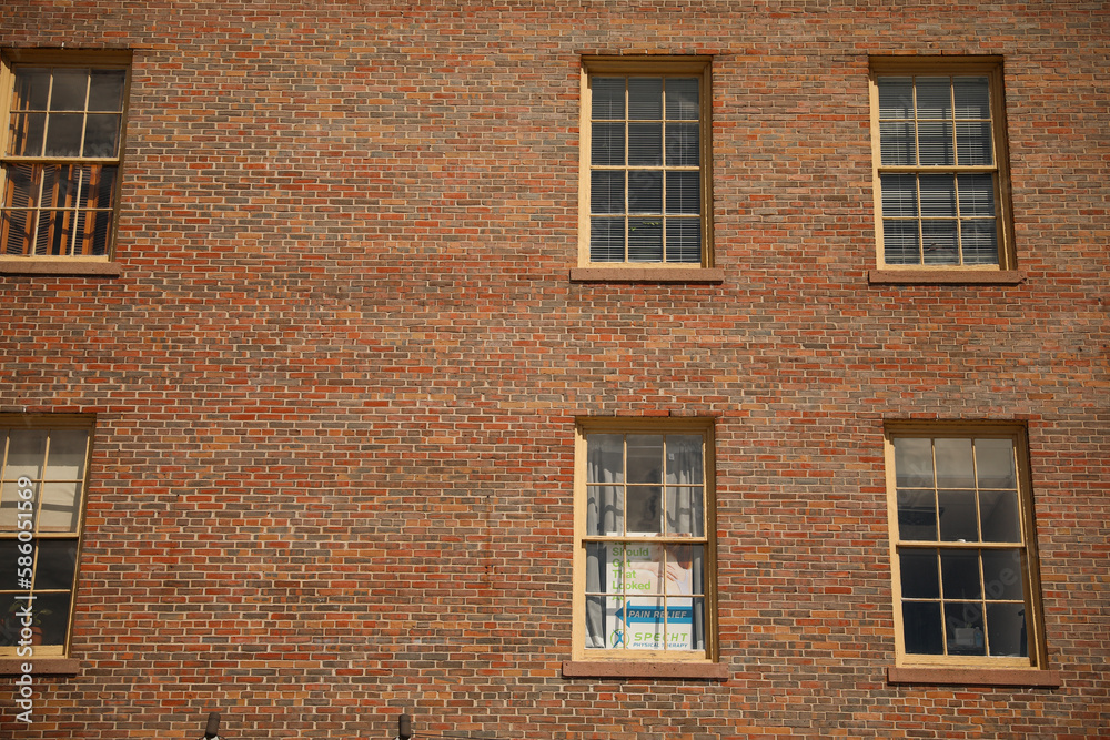A multi-story brick building featuring a mix of commercial offices and residential apartments, with classic architectural details and large windows.
