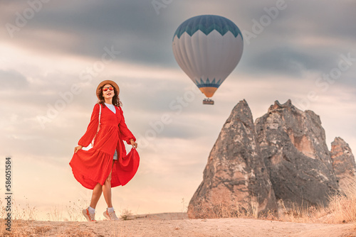 A lone figure in a pretty dress watched the air balloons ascend in Cappadocia, Turkey. Her dark hair lightly blew in the breeze, and a look of wonder shone in her eyes.