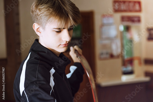 Teen leans on a snowboard at the box office