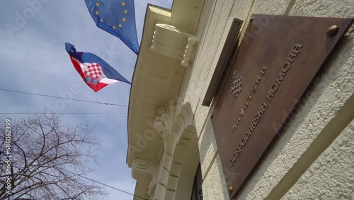 Croation flag and the flag of Europian Union against blue sky in on the state chamber building Zagreb, Croatia photo
