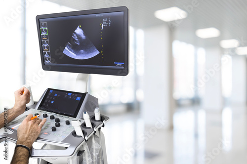 Ultrasound or sonogram procedure. Doctor hand holding an ultrasound sensor. Ultrasound examination.Screen of an ultrasound machine with a heart image.
