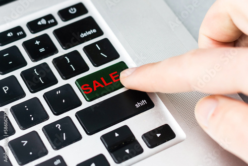 The finger pressing the sell button on the computer keyboard, believing bitcoin has changed the trend will sell.