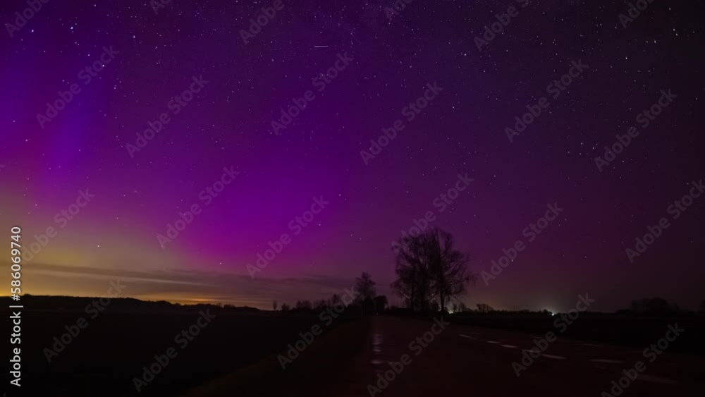 Timelapse shot of highway under colorful polar lights aurora borealis along rural countryside at night time. Timelapse shot of highway under colorful polar lights aurora borealis along rural countryside at night time.