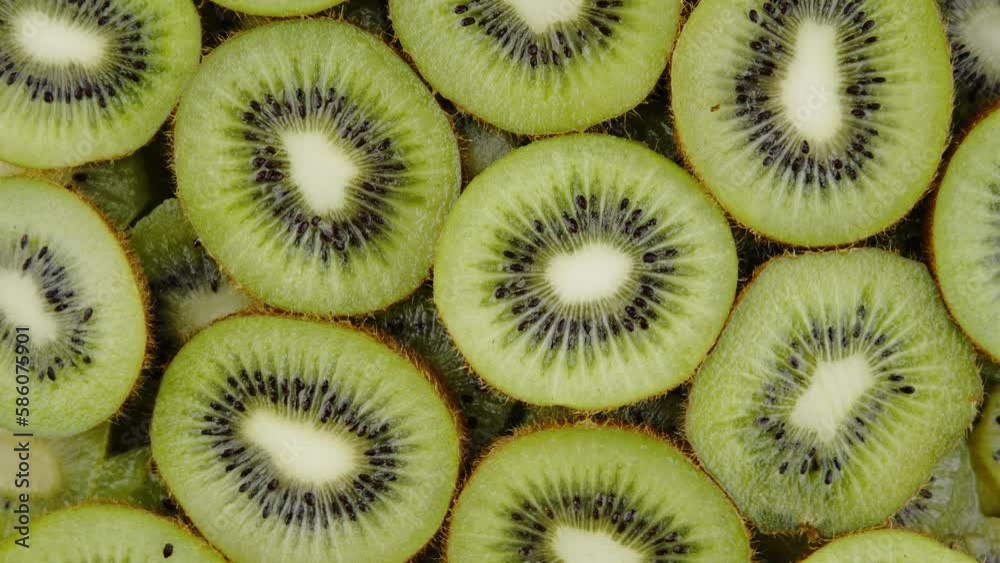 Macro Shot of Rotating Kiwi Fruit Slices on Black Background. A Perfect Snack for a Refreshing Break. Macro Shot of Rotating Kiwi Fruit Slices on Black Background. A Perfect Snack for a Refreshing Break.