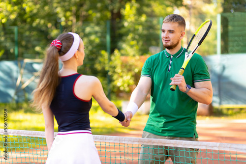 couple tennis players playing on court. end of match. man and girl handshaking after match. daylight saving time family. healthy lifestyle, amateur sports, unusual date