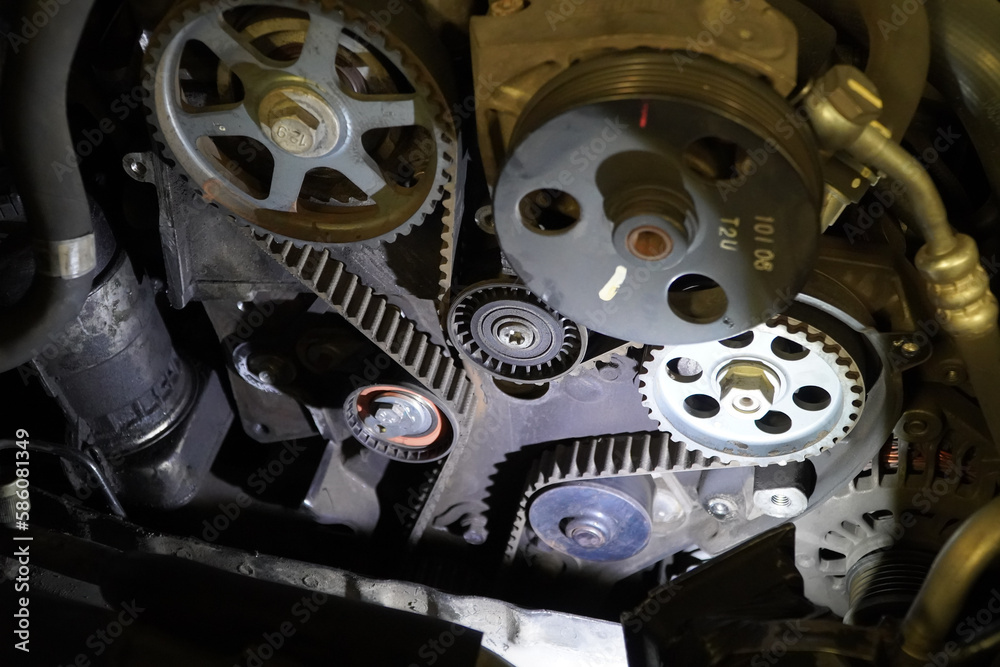 Old timing belt with rollers mounted on an old engine in the garage
