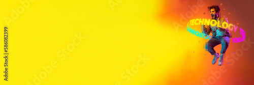 Banner with jumping and screaming man with neon lettering technology around body over yellow and orange background. Copy space for ad