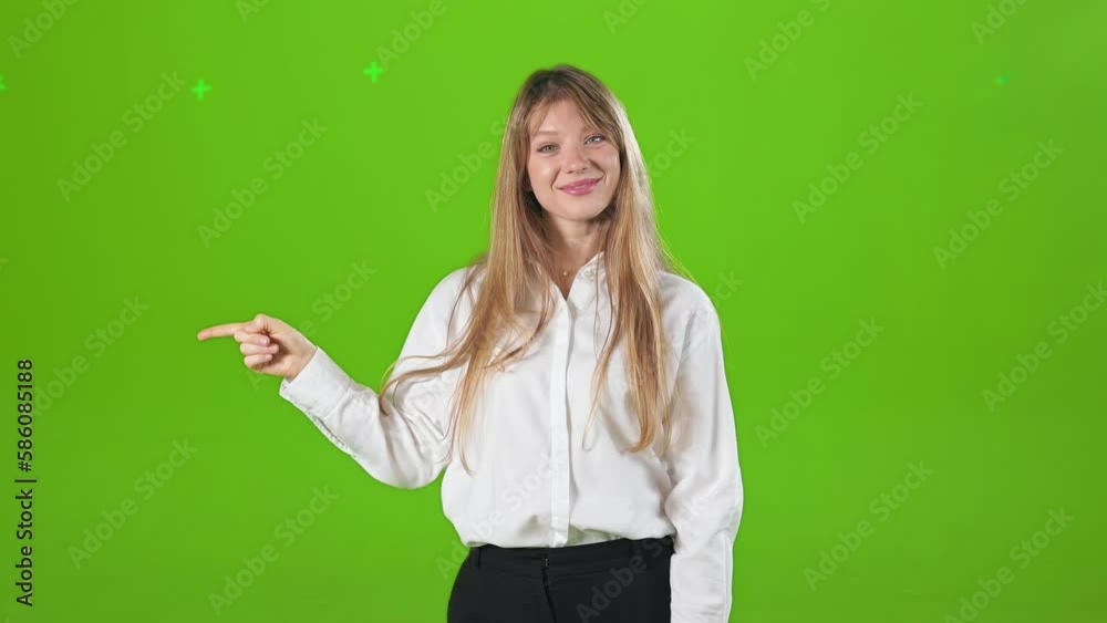 Front view of cheerful, smiling lady wearing official clothes, standing, posing in studio. Pretty, blonde woman stretching hand, pointing. Concept of happiness and sincere emotions. Front view of cheerful, smiling lady wearing official clothes, standing, posing in studio. Pretty, blonde woman stretching hand, pointing. Concept of happiness and sincere emotions.