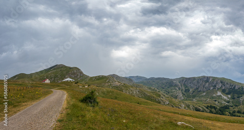 Mountain landscape with dramatic stormy clouds in sky.