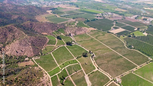 Aerial view flying across rural patchwork vineyard landscape in the Chilean Rapel valley, tilt up to Andes mountain range photo