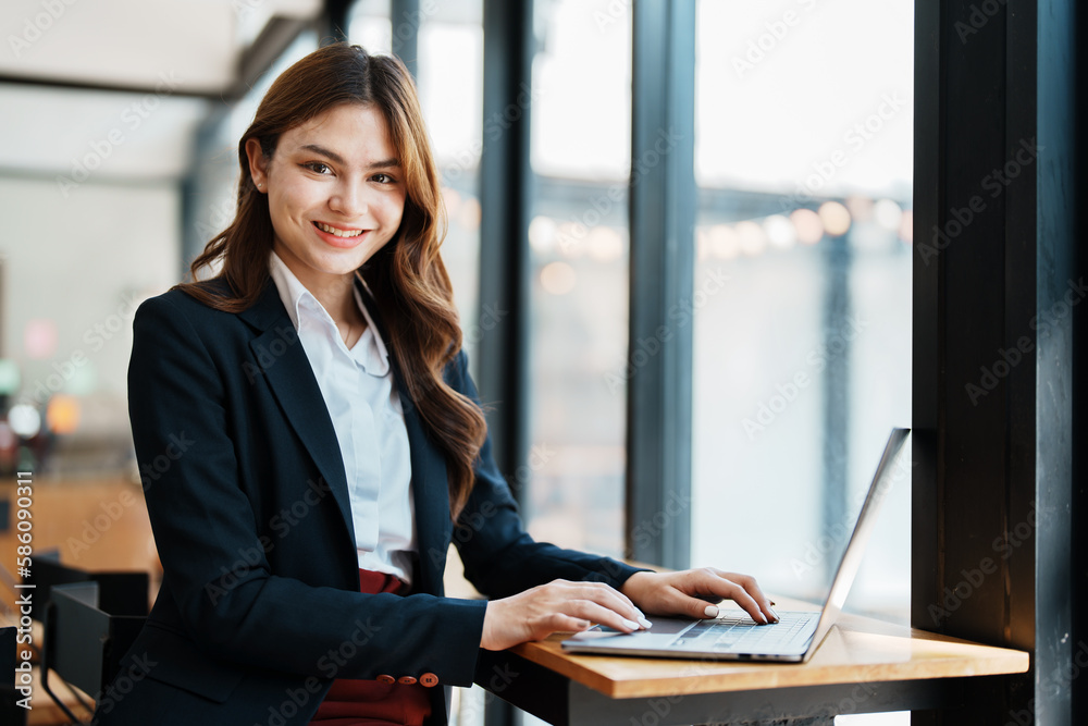 Beautiful young teen asian businesswoman using laptop computer and paperworks with planning working on financial document, tax, exchange, accounting and Financial advisor