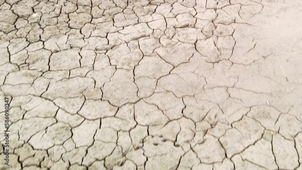 Close up of dry cracked mud bottom of dried out river, severe drought, dolly in