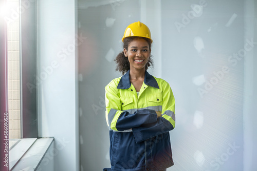 Portrait of black woman engineer cross her arms at chest, looking at camerra with smile of happiness and success. photo