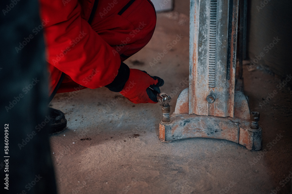 Man setting up a concrete core driller Man setting up a concrete core driller