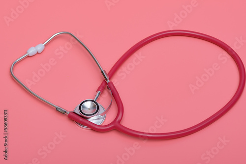 Czerwony stetoskop medyczny na różowym tle photo