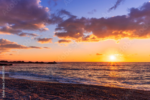 empty beach with surf during beautiful sunrise or sunset with surf  clouds and golden sun