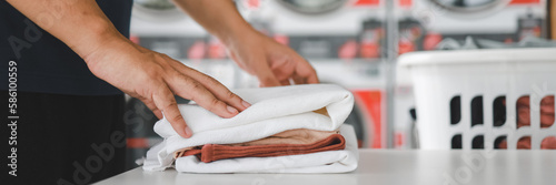 Man doing launder holding basket with dirty laundry of the washing machine in the public store. laundry clothes concept