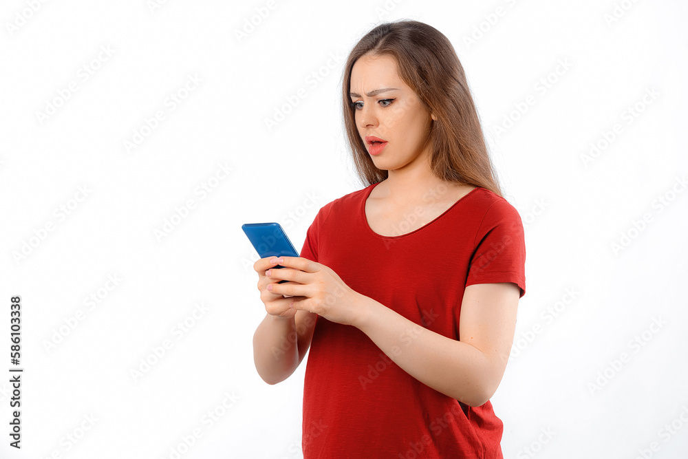 Portrait of lovely young woman using mobile phone, texting message, watching in smartphone with amazed face, standing over white background Portrait of lovely young woman using mobile phone, texting message, watching in smartphone with amazed face, standing over white background