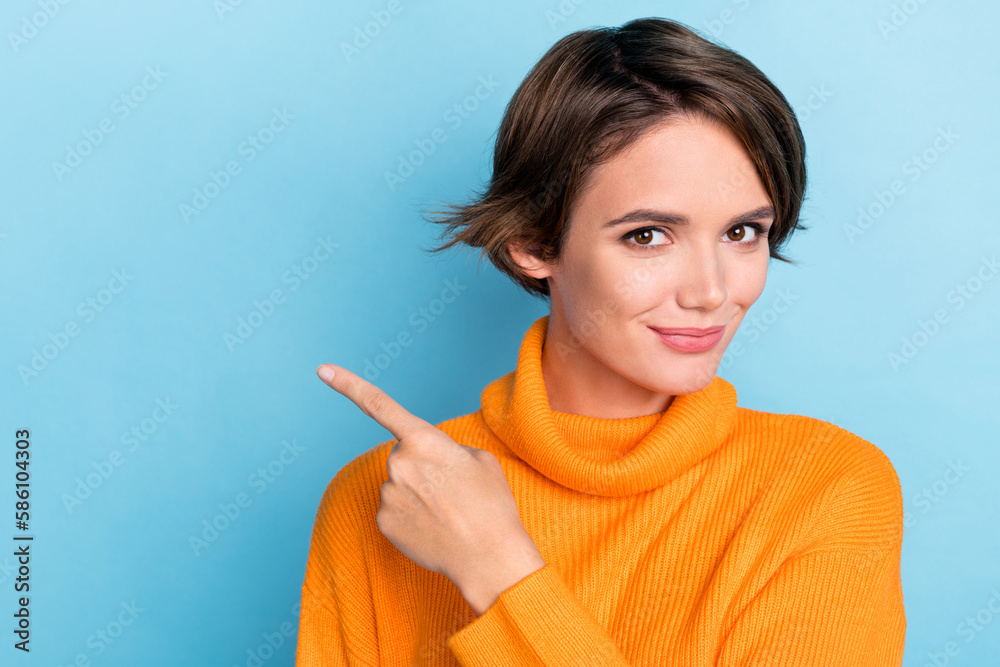 Photo portrait of pretty young girl point finger empty space recommend dressed stylish orange outfit isolated on blue color background Photo portrait of pretty young girl point finger empty space recommend dressed stylish orange outfit isolated on blue color background