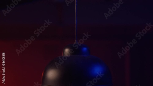 Close up view of a ceiling lamp being lit. Dark interior, basement, interrogation room, poker night photo