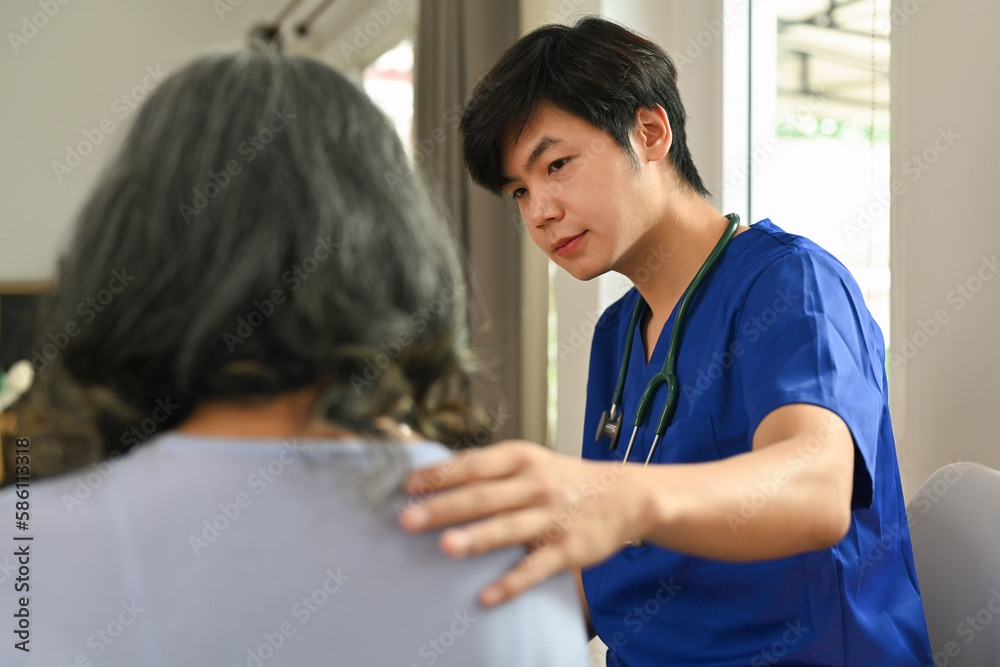 Obraz premium Doctor touching shoulder comforting upset senior patient after medical diagnosis at clinic. Elderly healthcare concept