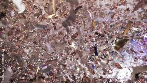 People dancing in nightclub. It's raining confetti on the crowd at the party area