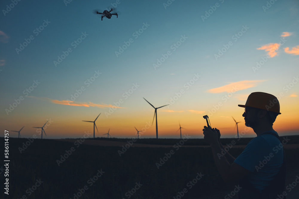 Engineer mechanic using drone for inspection in a windmill farm park. Engineer mechanic using drone for inspection in a windmill farm park.