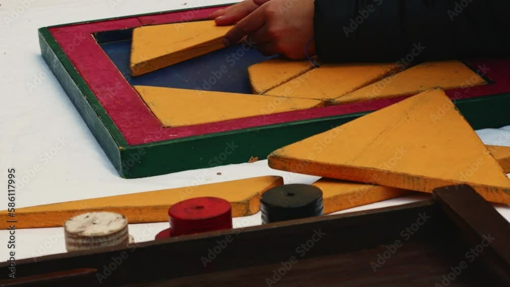 children play with a wooden tangram puzzle during an event at a fair